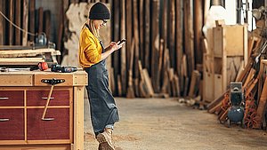 Frau in holzverarbeitendem Handwerksbetrieb