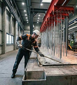 An employee works on a hot-dip galvanizing kettle.