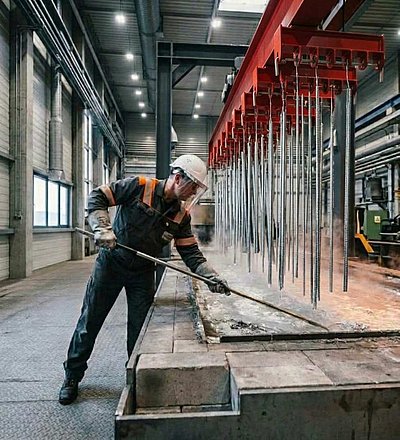 Ein Mitarbeiter arbeitet an einem Feuerverzinkungskesse.