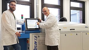 Detlef Paschke und Jonas Sutmann an der Reflow-Anlage
