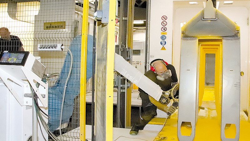 Lackierroboter und Mensch
