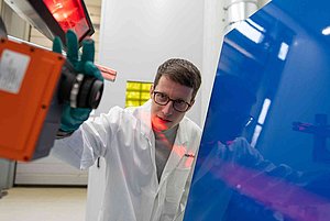Ein Labormitarbeiter analysiert mit einer Inline-fähigen Hyperspektralkamera eine lackierte Motorhaube