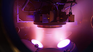 Argon-Plasma in der Vakuumkammer beim Magnetron-Sputtern, mit dem Substrat in der Bildmitte. 